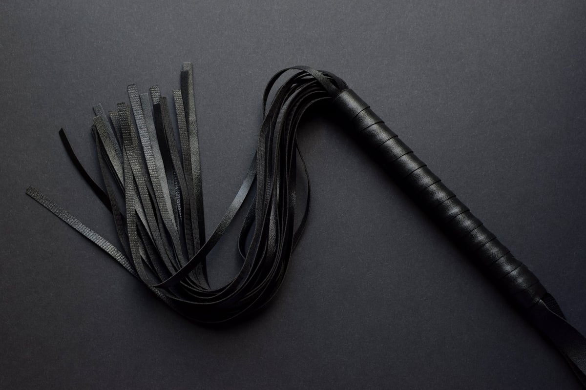 Leather black whip on dark background