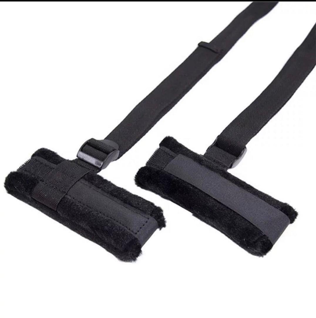 Pair of black foam barbell bar pads with nylon straps for shoulder protection during weightlifting exercises