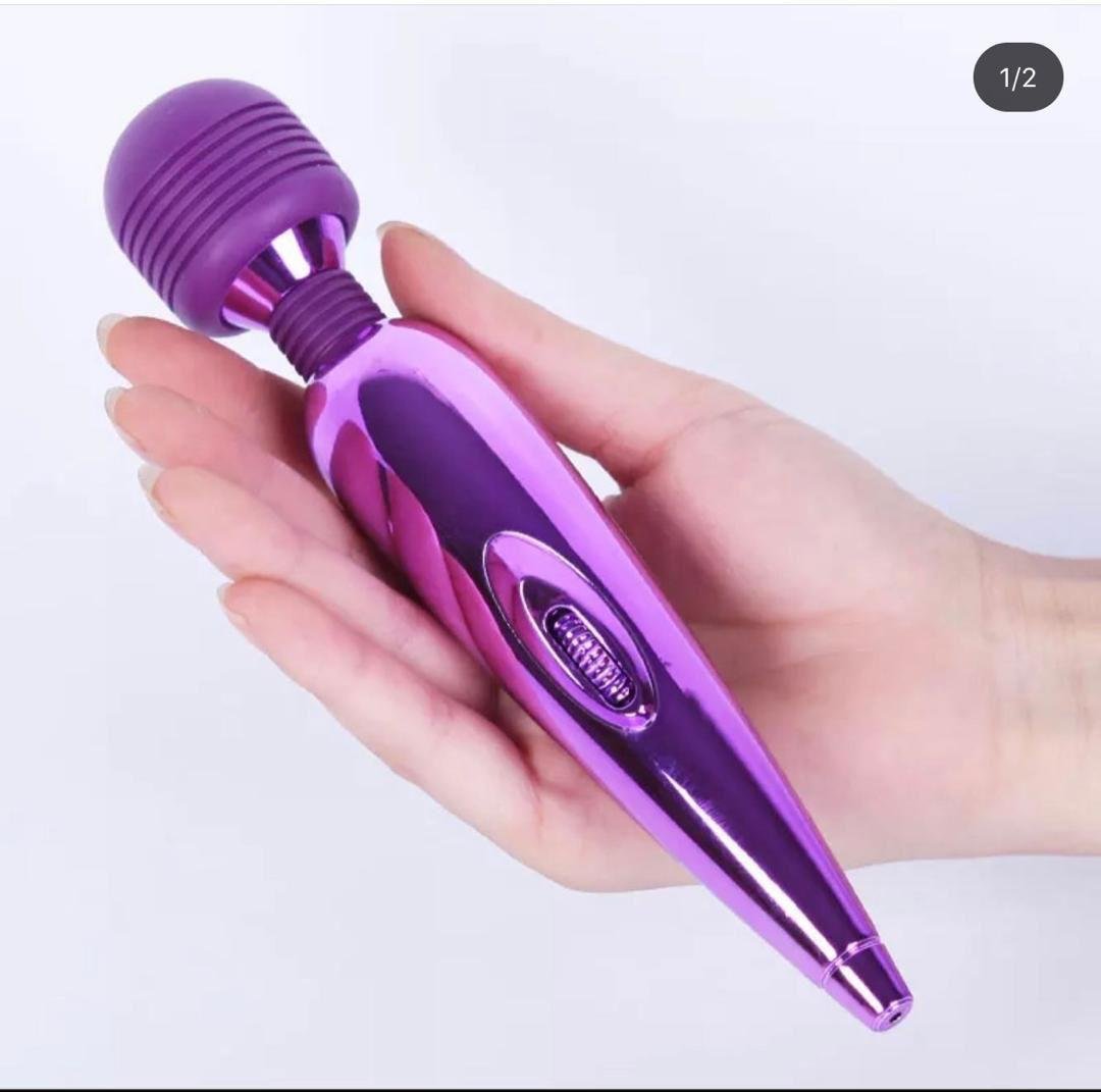 Hand holding a purple wand vibrator with ribbed head and control buttons against white background