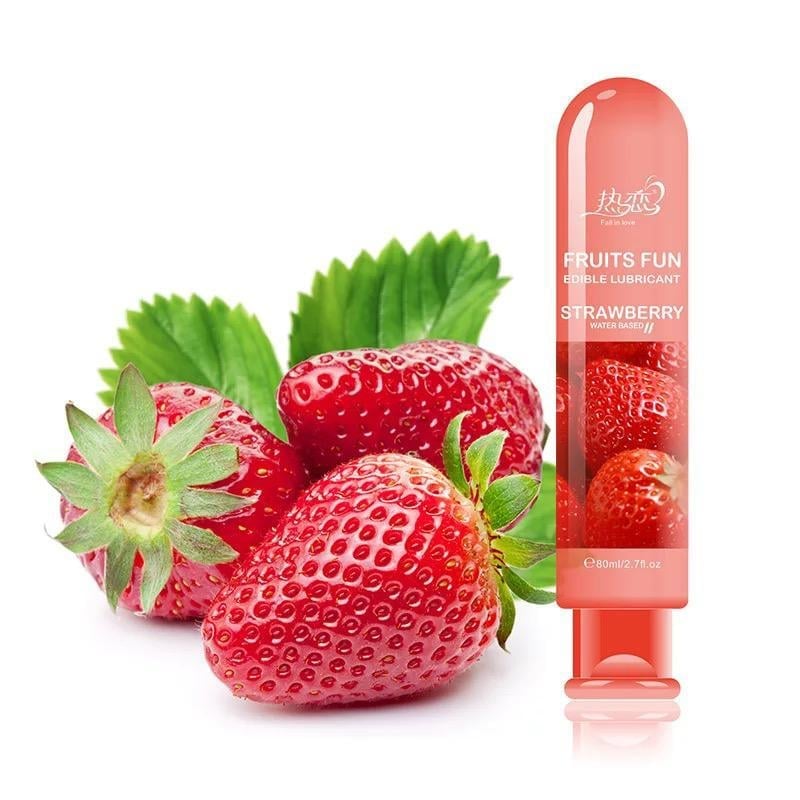 Strawberries next to a strawberry-scented personal lubricant bottle